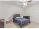 Cozy bedroom with neutral walls, ceiling fan, and dark wood furnishings offer comfort and style at 14107 W Christy Dr, Surprise, AZ 85379