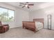 Cozy bedroom with a wooden bed frame, recliner, ceiling fan, and window at 14107 W Christy Dr, Surprise, AZ 85379