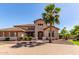Stunning home featuring manicured landscaping, a brick driveway, and a grand entrance with a towering palm tree at 14107 W Christy Dr, Surprise, AZ 85379