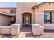Inviting front porch with stone pillars and a decorative glass door, creating a warm welcome at 14107 W Christy Dr, Surprise, AZ 85379