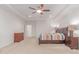 Large bedroom with wood furniture, carpet, and a tray ceiling with a ceiling fan at 14107 W Christy Dr, Surprise, AZ 85379