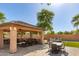 Outdoor patio features a large seating area, outdoor kitchen, and dining area, perfect for entertaining at 14107 W Christy Dr, Surprise, AZ 85379