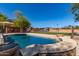 Backyard pool boasts a basketball hoop, fountains, desert landscaping and patio with outdoor seating and a sport court at 14107 W Christy Dr, Surprise, AZ 85379