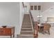 Inviting staircase with carpet and wood banister leading to the upper level, complemented by neutral tones and ample natural light at 14107 W Christy Dr, Surprise, AZ 85379