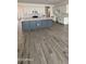 A large kitchen island with white countertops and grey base cabinets, set against wood-look floors at 14800 W Lariat Ln, Surprise, AZ 85387
