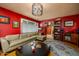 Cozy living room with red walls, a stylish chandelier, and comfortable leather seating at 15212 N 37Th Ave, Phoenix, AZ 85053