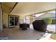 Inviting covered patio with dining area and grill, overlooking the backyard and pool area at 15212 N 37Th Ave, Phoenix, AZ 85053