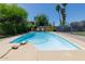 Sparkling pool with lounge chairs, surrounded by lush landscaping for a private backyard oasis at 15212 N 37Th Ave, Phoenix, AZ 85053