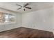 Cozy bedroom featuring wood laminate flooring, a ceiling fan, and natural light at 1643 W Naranja Ave, Mesa, AZ 85202