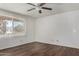 This bedroom features wood laminate flooring, a ceiling fan, and natural light at 1643 W Naranja Ave, Mesa, AZ 85202