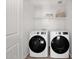 Modern laundry room with front-load washer and dryer, a storage shelf, and luxury vinyl plank flooring at 16875 N 12Th St # 31, Phoenix, AZ 85022
