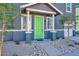 A close-up of the covered front porch featuring a bright green door, white trim, and decorative landscaping at 16875 N 12Th St # 33, Phoenix, AZ 85020