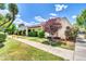 Well-kept home exterior showing mature trees, a neatly landscaped lawn, and a tidy sidewalk and street at 1733 N Miller Rd, Scottsdale, AZ 85257