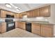 Updated kitchen featuring wooden cabinets, granite countertops, black appliances, and neutral paint at 1733 N Miller Rd, Scottsdale, AZ 85257