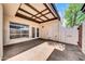 Private patio area featuring textured concrete flooring, an airy pergola roof, and access to the home through French doors at 1733 N Miller Rd, Scottsdale, AZ 85257
