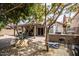 A serene backyard featuring a covered patio, mature trees, and ample space for outdoor activities and relaxation at 19824 N 14Th Pl, Phoenix, AZ 85024