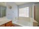 Inviting bathroom with a soaking tub under a glass block window at 1983 W Allens Peak Rd, Queen Creek, AZ 85144