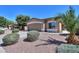 Tan home with well maintained desert landscaping including several decorative bushes and a palm tree at 1983 W Allens Peak Rd, Queen Creek, AZ 85144