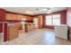 Well-lit kitchen with tile flooring, oak cabinets, island and matching appliances at 1983 W Allens Peak Rd, Queen Creek, AZ 85144