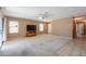 Bright living room with a ceiling fan, tile and carpet flooring, and a large sliding glass door at 1983 W Allens Peak Rd, Queen Creek, AZ 85144