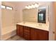 Well-lit bathroom with dual sinks, vanity, large mirror, and a bathtub/shower combination at 21050 E Tierra Grande --, Queen Creek, AZ 85142