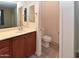 Bathroom featuring a toilet, sink with wood cabinet, mirror, vanity lighting, and wood look floor at 21050 E Tierra Grande --, Queen Creek, AZ 85142