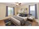 A primary bedroom featuring a ceiling fan, two windows, and neutral decor at 21050 E Tierra Grande --, Queen Creek, AZ 85142