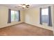 Inviting bedroom with a ceiling fan, two windows with curtains, and plush carpeting at 21050 E Tierra Grande --, Queen Creek, AZ 85142