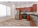 Well-lit kitchen features stainless steel appliances, granite countertops, and wood cabinets at 21050 E Tierra Grande --, Queen Creek, AZ 85142