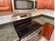 Close-up of oven and stovetop with granite countertops and stainless steel microwave at 21050 E Tierra Grande --, Queen Creek, AZ 85142