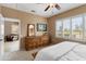Well-lit bedroom features a ceiling fan, carpet, a dresser and outdoor view at 22504 N San Ramon Dr, Sun City West, AZ 85375