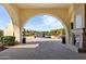 Covered patio with a fireplace looks out to a courtyard with fountain, palm trees and green fairways, ideal for entertaining at 22504 N San Ramon Dr, Sun City West, AZ 85375