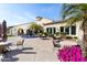 Outdoor patio area showing stylish seating, vibrant floral arrangements, and picturesque views of the community clubhouse at 22504 N San Ramon Dr, Sun City West, AZ 85375