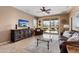 Comfortable living room with tile floors, leather furniture, and a view of the pool at 22504 N San Ramon Dr, Sun City West, AZ 85375