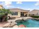 Private pool with lush landscaping, chairs, and covered patio at 22504 N San Ramon Dr, Sun City West, AZ 85375
