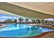 Sparkling pool with lounge chairs under a large sunshade offering a resort-like experience for residents at 22504 N San Ramon Dr, Sun City West, AZ 85375