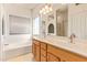 Bright bathroom featuring a double sink vanity, a large mirror, and a soaking tub for relaxation at 2327 E Edna Ave, Phoenix, AZ 85022