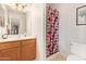 Bathroom features a wooden vanity, decorative framed mirror, and shower at 2327 E Edna Ave, Phoenix, AZ 85022