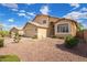 Well-maintained tan home featuring a two-car garage, desert landscaping, and mature greenery at 2327 E Edna Ave, Phoenix, AZ 85022