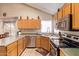 Functional kitchen with wood cabinets, stainless steel dishwasher, and ample counter space for food preparation at 2327 E Edna Ave, Phoenix, AZ 85022