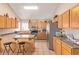 Spacious kitchen featuring wood cabinets, stainless steel appliances, and a breakfast bar for casual dining at 2327 E Edna Ave, Phoenix, AZ 85022