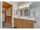 Bathroom featuring double sinks, wooden cabinetry and a walk-in closet with custom shelving at 2340 W Myrtle Dr, Chandler, AZ 85248