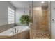 Well-lit bathroom featuring a soaking tub, glass block window and pebble-tiled shower with a built-in bench at 2340 W Myrtle Dr, Chandler, AZ 85248