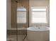 Spa-like bathroom with soaking tub, window, and glass shower enclosure with hexagon tile wall accent at 24088 S 218Th Pl, Queen Creek, AZ 85142