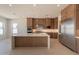 Open-concept kitchen featuring an island, stainless steel appliances, and natural light at 24088 S 218Th Pl, Queen Creek, AZ 85142