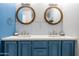 Stylish bathroom with double sinks, round mirrors, blue cabinetry, and white countertop at 2430 E Hermosa Dr, Tempe, AZ 85282