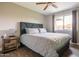 Bedroom features a ceiling fan, window, and wood-look floors for a sleek design at 2430 E Hermosa Dr, Tempe, AZ 85282