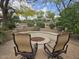 Serene backyard featuring a fire pit with chairs, lush greenery, and mature trees for relaxing outdoor living at 27158 W Potter Dr, Buckeye, AZ 85396