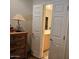 A view into the bathroom, with wood dresser and decorative lamp at 27158 W Potter Dr, Buckeye, AZ 85396