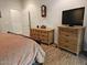 This main bedroom offers a rustic wood dresser and floors and a neutral color scheme at 27158 W Potter Dr, Buckeye, AZ 85396